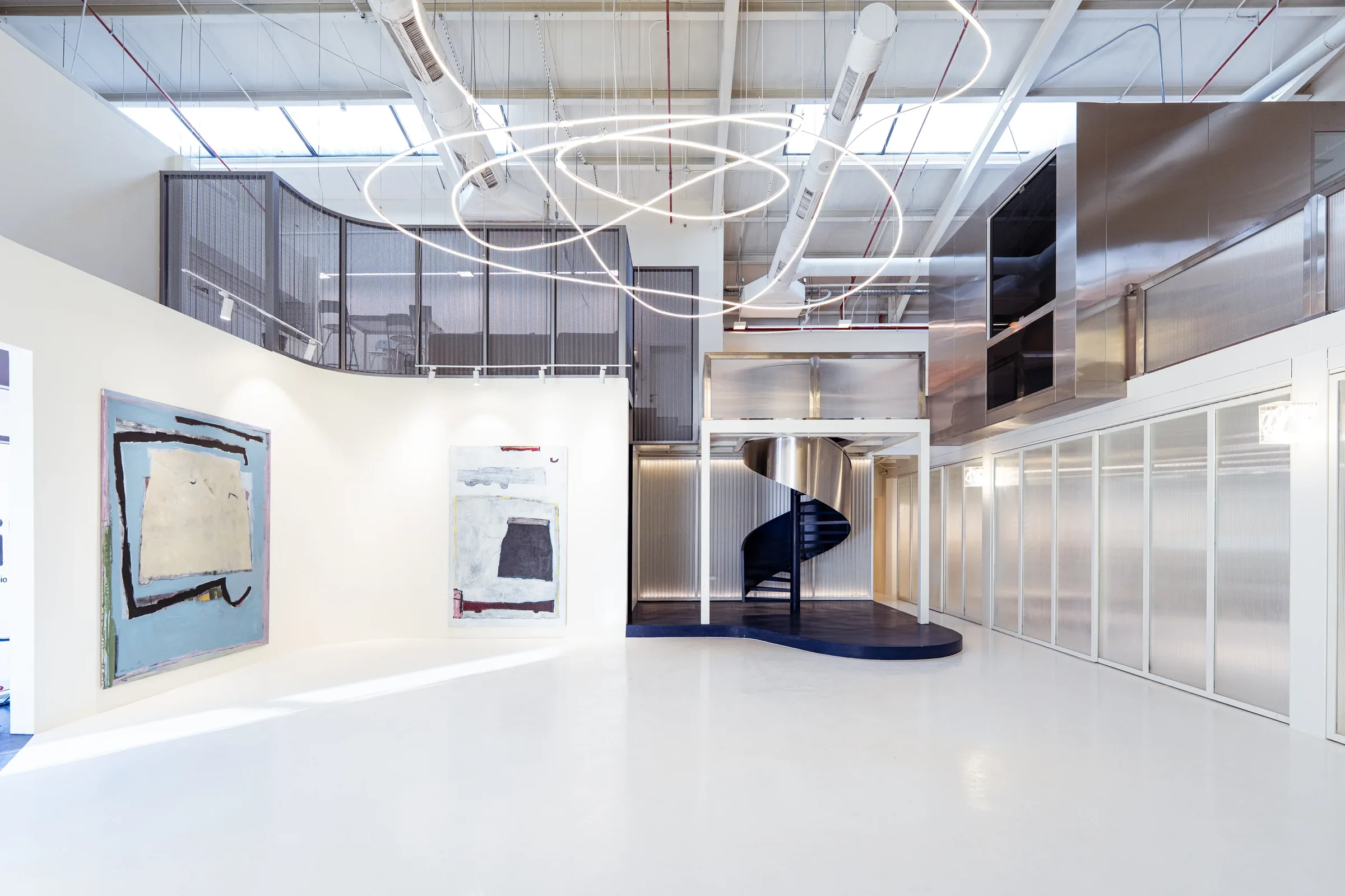 Lift, a creative gallery in JAX District, Riyadh, designed by Quartz Architects, with its blue spiral stair and looping light sculpture