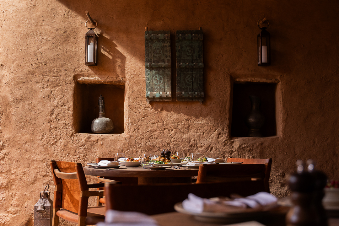 Joontos, the restaurant at Dar Tantora The House Hotel, AlUla, set against a restored mud brick wall