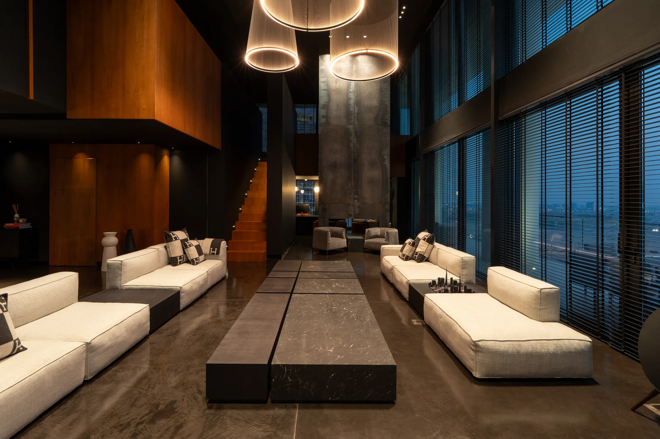 The double height lounge at Noir Matière, Lana Residences, Dubai, its seating drawn along a single axis
